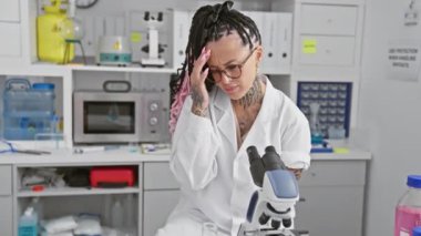 Dikkat çekici İspanyol ampüte kadın bilim adamı titizlikle test tüpü örneğini laboratuarda mikroskop ile ölçüyor, kapalı alanda tıbbi araştırma hünerleri sergiliyor.