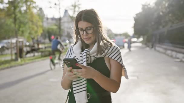 Atrakcyjna Młoda Kobieta Nosi Okulary Pomocą Smartfona Słonecznej Ulicy Miejskiej — Wideo stockowe