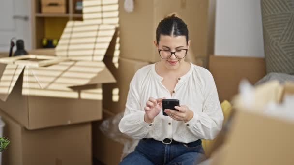 Young Beautiful Hispanic Woman Using Smartphone Sitting Sofa New Home — Stock Video
