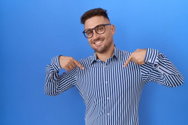 Sakallı, gözlüklü, kendine güvenen, gülümseyen, kendini gururlu ve mutlu gösteren İspanyol bir adam.. 