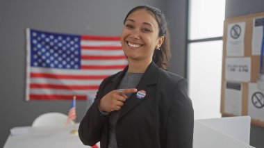 Gülümseyen İspanyol bir kadın, bir üniversite seçim merkezinde Amerikan bayrağı olan 