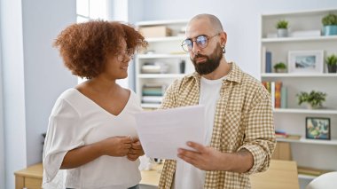 İki iş ortağı, bir erkek ve bir kadın, bir iş belgesini okumaya dalmışlar, ofisteki iş hakkında tutkuyla konuşuyorlar.