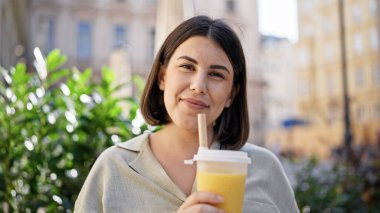 Genç ve güzel İspanyol kadın Viyana sokaklarında köpüklü çay içiyor.