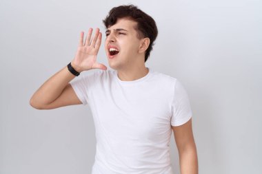 Gündelik beyaz tişört giyen, el ele tutuşarak bağıran ve yüksek sesle bağıran iki kişilikli olmayan genç bir adam. iletişim konsepti. 