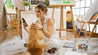 Genç İspanyol bir sanatçı, büyüleyici bir güzellik, çizim dersinin ortasında kendini akıllı telefona kaptırmış, stüdyo zemininde sadık bir köpekle oturuyor.