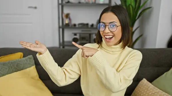 Hispanic Woman Smiling Gesturing Presentation Living Room Glasses Yellow Sweater — Stock Photo, Image