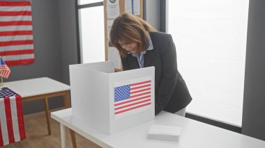 Amerikan seçim merkezinde bayrak sallayan olgun bir kadın..