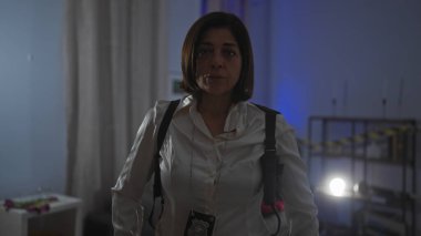 Ofiste kameraya dikkatle bakan orta yaşlı bir İspanyol kadın dedektif..