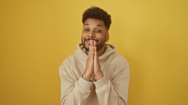 Elleri kelepçeli, sarı arka planda kapüşonlu bir Amerikalı 'nın portresi..