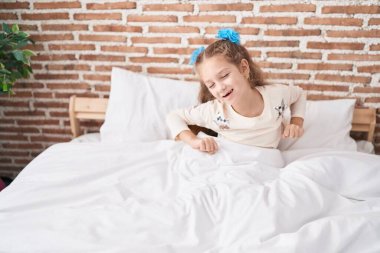 Sevimli beyaz kız yatak odasında kollarını açarak uyanıyor.