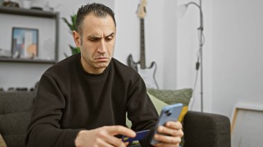 Evde telefon ve kredi kartı olan sıkıntılı İspanyol bir adam mali sıkıntıları gösteriyor.