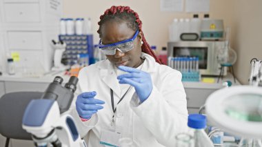 Örgü ören Afrikalı kadın bilim adamı bir laboratuvar ortamında profesyonellik ve uzmanlık tasvir ediyor..