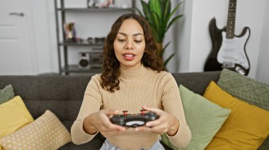 Rahat, modern bir oturma odasında video oyunu oynayan odaklanmış bir kadın..