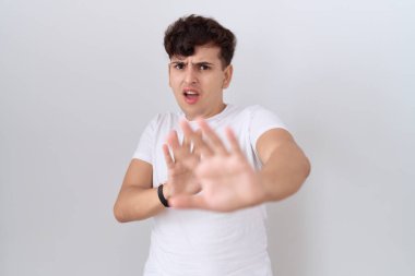 Gündelik beyaz t-shirt giyen, korku ifadesinden korkan, korkan, el kol hareketi yapmayan, şok içinde bağıran genç bir adam. panik konsepti. 