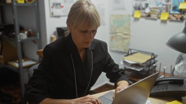 Focused woman detective working on a laptop in a cluttered police department office, evidence board in the background. clipart