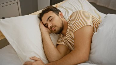 Sakallı genç bir İspanyol, yatak odasında huzur içinde uyuyor. Rahatlık ve rahatlık tasvir ediyor..