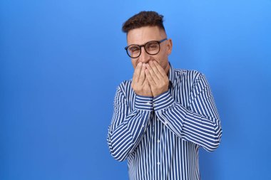 Sakallı, gözlüklü, gülen, utangaç, ağzı ellerle kaplayan, dedikodu ve skandal konsepti olan İspanyol bir adam. 