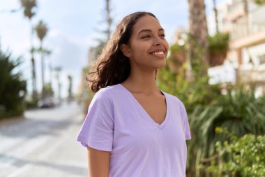Young african american woman smiling confident looking to the side at street