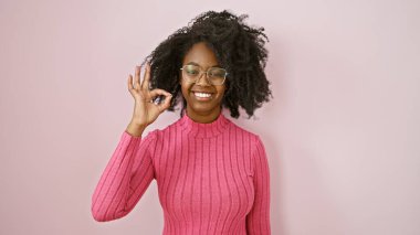 Gözlüklü Afrikalı Amerikalı bir kadın pembe arka planlı 