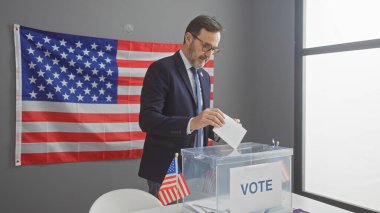 Amerikan seçim kolejinde oy kullanan orta yaşlı bir adam bayrak arkaplanıyla.