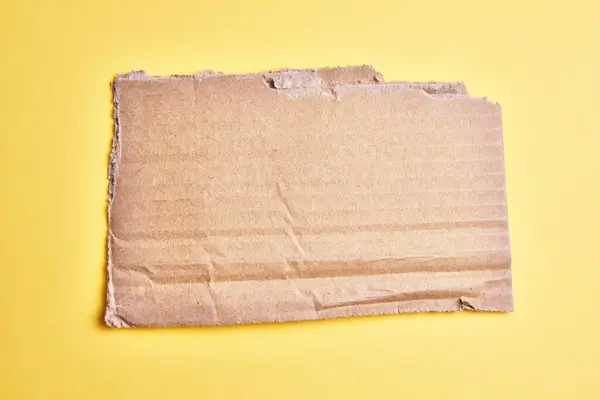 One Ripped Piece Cardboard Material Isolated Yellow Background — Stock Photo, Image
