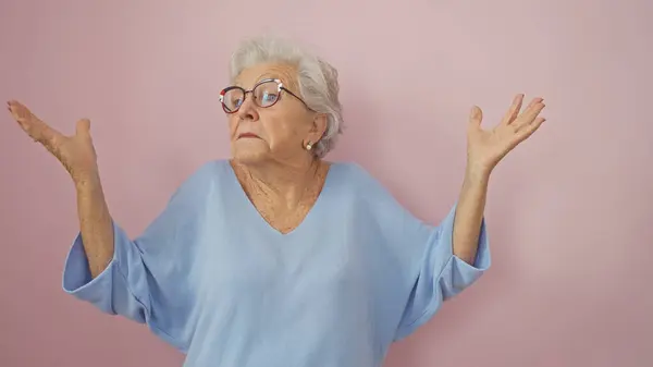 Perplexed Senior Woman Gray Hair Glasses Gesturing Uncertainty Pink Background — Stock Photo, Image