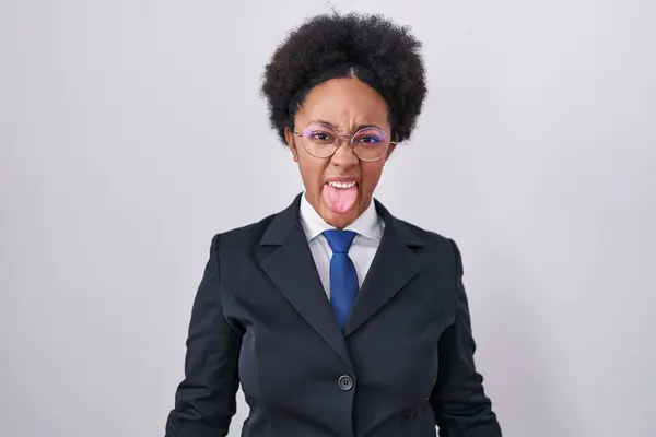 美丽的非洲女人 身穿商务夹克 戴着眼镜 带着滑稽的表情伸出舌头 情感概念 — 图库照片