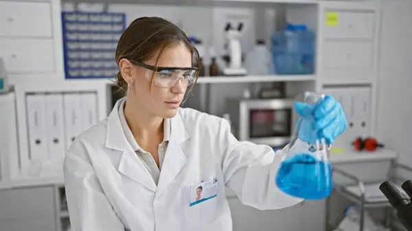 Attractive young hispanic female scientist measuring liquid in a test tube, engrossed in her groundbreaking medical research at the bustling lab, showcasing the beauty of scientific endeavor.