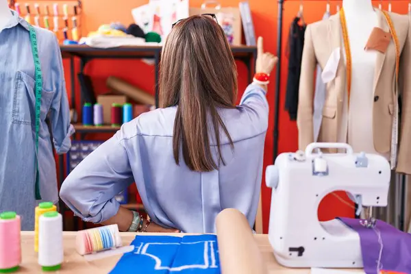 Hispanic Young Woman Dressmaker Designer Atelier Room Posing Backwards Pointing — Stock Photo, Image