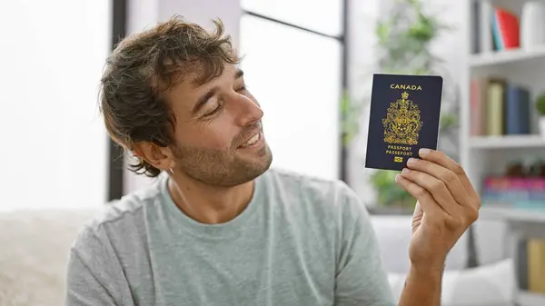 Joven Feliz Sonriendo Sentado Casa Sofá Sosteniendo Pasaporte Canadiense Listo Imagen De Stock