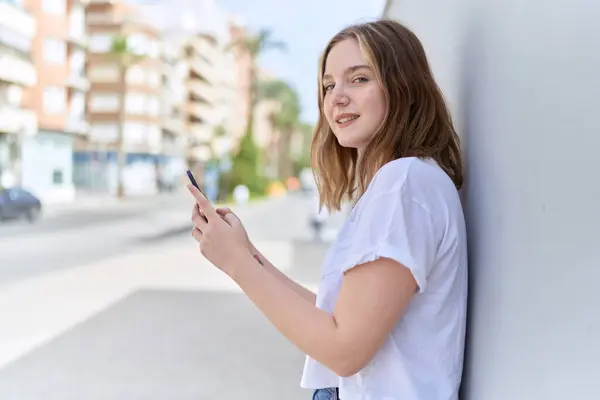 Beyaz Bir Kadın Sokakta Akıllı Telefon Kullanarak Gülümsüyor Stok Fotoğraf