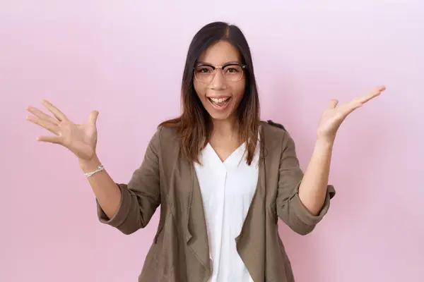 Mujer China Mediana Edad Con Gafas Sobre Fondo Rosa Celebrando Fotos de stock libres de derechos