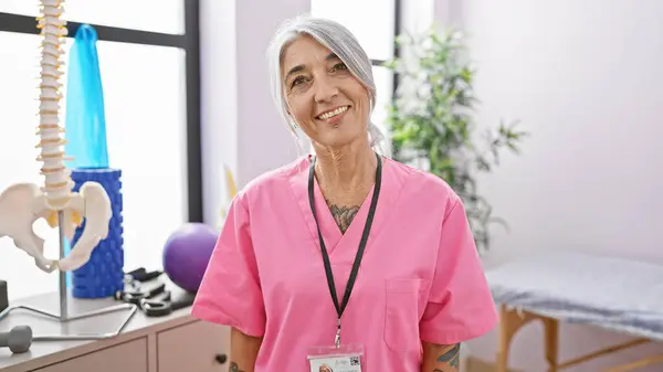 Die Lächelnde Selbstbewusste Grauhaarige Physiotherapeutin Mittleren Alters Genießt Ihre Arbeit Stockbild