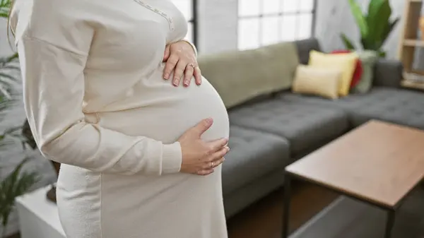 Close Pregnant Hispanic Woman Standing Cozy Living Room Hand Belly royaltyfrie gratis stockfoto