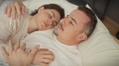 Huzurlu bir çift, birlikte sakin bir andan zevk alır, beyaz çarşaflı rahat bir yatakta uzanıp, aşkı ve samimiyeti tasvir ederler..