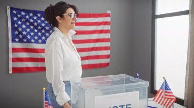 Olgun bir kadın, oy sandığının yanında biz bayraklarla Amerikan demokrasisini sembolize ediyor..