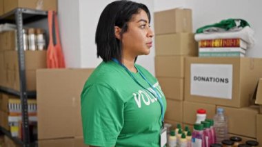 İspanyol kadın gönüllü depoda duruyor ve kutular dolusu bağışla birlikte.