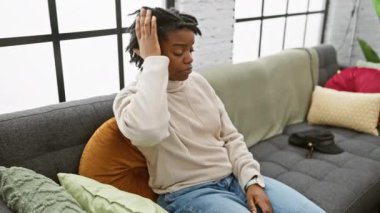 Rasta takmış endişeli genç siyahi kadın rahat koltukta kol saatini kontrol ediyor, işe geç kalıyor.?