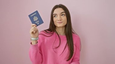 Neşeli genç Latin, elinde ABD pasaportu, parlak bir zeka, pembe bir arka plan üzerinde bir numaralı fikri ateşliyor.