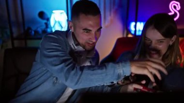 Bir erkek ve kadın, geceleri neon ışıkları olan karanlık bir odada oyun oynamaktan zevk alırlar..