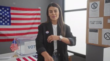 Amerikan oy verme merkezinde bayrağıyla kollarını kavuşturmuş kendine güveni tam bir İspanyol kadın.
