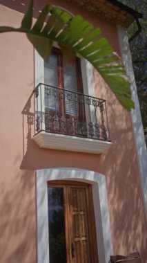 Geleneksel Akdeniz evi, ahşap balkonu, kapısı ve tuhaf bir köyde yeşil yaprakları var..