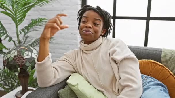 Vreugdevolle Jonge Zwarte Vrouw Met Dreadlocks Ontspannen Een Gezellige Bank — Stockvideo