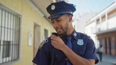 Afro-Amerikan polisi şehir sokaklarından telsizle bildiriyor.