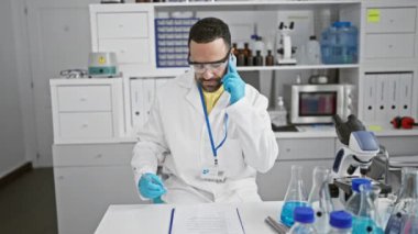 Laboratuvardaki İspanyol bilim adamı laboratuvar önlüğü, eldiven ve gözlük takıyor.