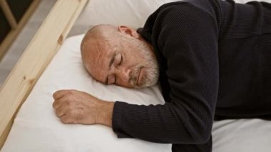 Sakallı, olgun kel bir adam. Tahta bir yatakta, beyaz bir yastıkta huzur içinde uyuyor. Huzur ve konfor tasvir ediyor..