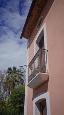 Akdeniz 'de balkon, mavi gökyüzü ve bereketli yeşilliklerle donatılmış bir bina cephesi