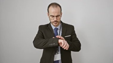 Şaşırmış işadamı zamanı kontrol ediyor, el kol hareketleri yapıyor, gözlük takıyor, kravat takıyor, takım elbise giyiyor, beyaz arka planda duruyor..