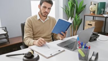 Modern ofis ortamında dizüstü bilgisayarı, durağanı, bitkileri ve küresi olan yakışıklı İspanyol bir adam..