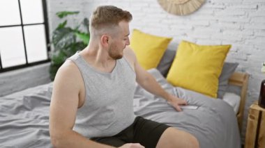 Akvaryumdaki sakallı adam modern yatak odasında akıllı telefon kullanıyor.